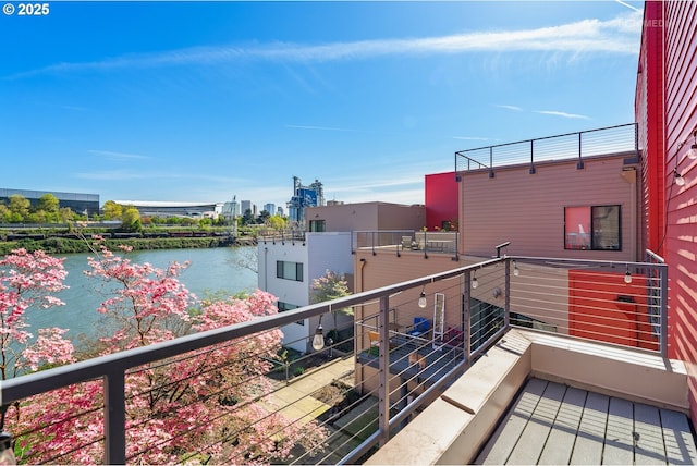 balcony featuring a city view and a water view