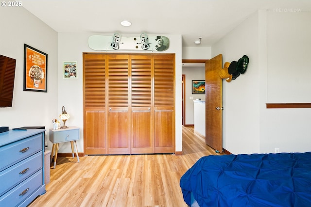 bedroom with light wood-type flooring and baseboards