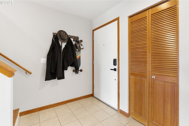 entryway featuring baseboards and light tile patterned flooring