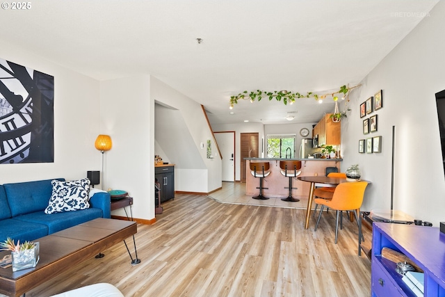 living room featuring light wood-type flooring and baseboards