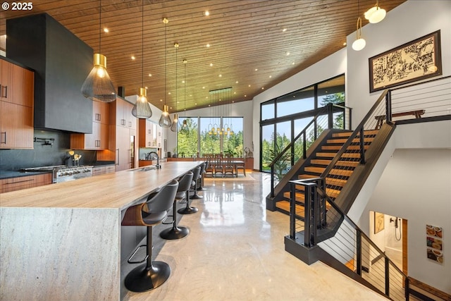 725 NW Angel Heights Rd, Stevenson, WA 98648 - kitchen with a large island with sink, a sink, pendant lighting, concrete flooring, and high vaulted ceiling