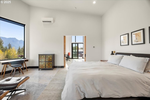 725 NW Angel Heights Rd, Stevenson, WA 98648 - bedroom featuring finished concrete floors, a towering ceiling, baseboards, a mountain view, and a wall unit AC