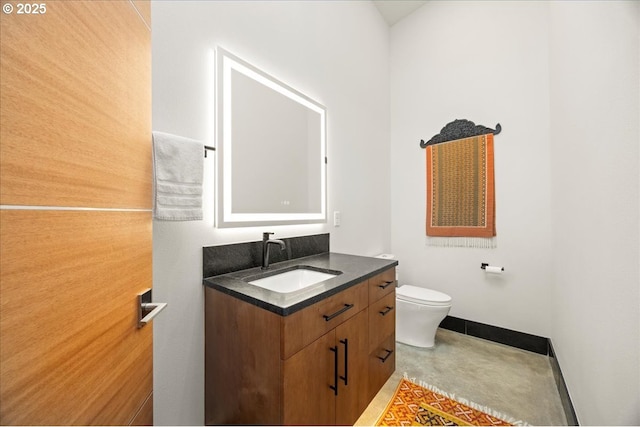 725 NW Angel Heights Rd, Stevenson, WA 98648 - bathroom featuring concrete floors, toilet, vanity, and baseboards