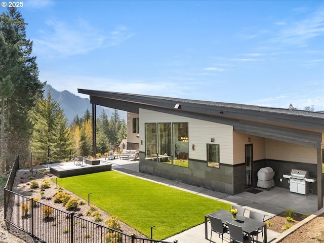 725 NW Angel Heights Rd, Stevenson, WA 98648 - back of property with a lawn, a mountain view, fence, and a patio