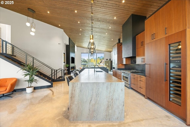 725 NW Angel Heights Rd, Stevenson, WA 98648 - kitchen featuring wall chimney range hood, a sink, wood ceiling, stainless steel range, and high vaulted ceiling