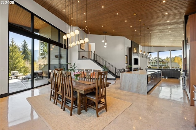 725 NW Angel Heights Rd, Stevenson, WA 98648 - dining space with high vaulted ceiling, stairway, wood ceiling, an inviting chandelier, and a wall of windows