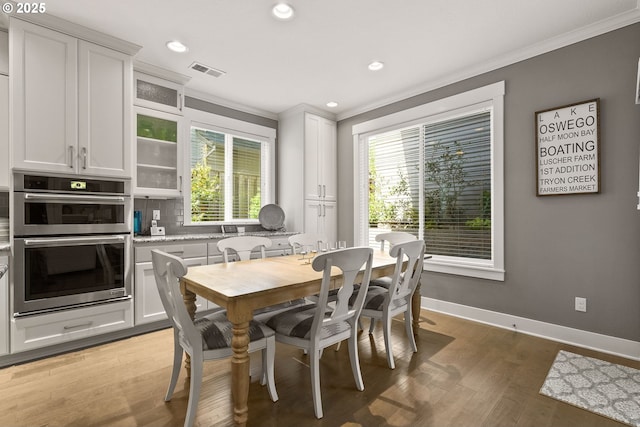 dining area with crown molding, recessed lighting, light wood-type flooring, and baseboards