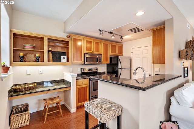 525 Springtree Ln, West Linn, OR 97068 - kitchen with stainless steel appliances, light wood-type flooring, a peninsula, rail lighting, and dark stone countertops