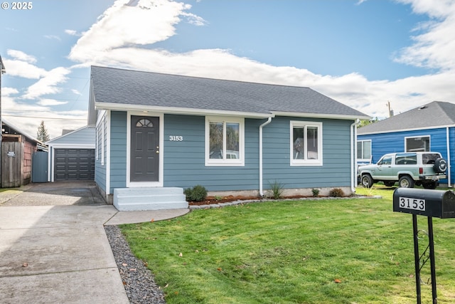 view of front of home featuring an outbuilding, a garage, and a front yard