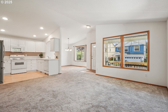 5661 J St, Washougal, WA 98671 - kitchen featuring white appliances, light carpet, open floor plan, lofted ceiling, and a chandelier
