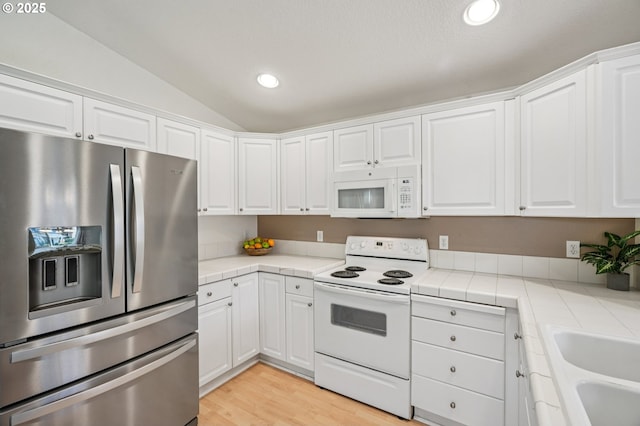 5661 J St, Washougal, WA 98671 - kitchen with white appliances, tile counters, lofted ceiling, white cabinetry, and recessed lighting