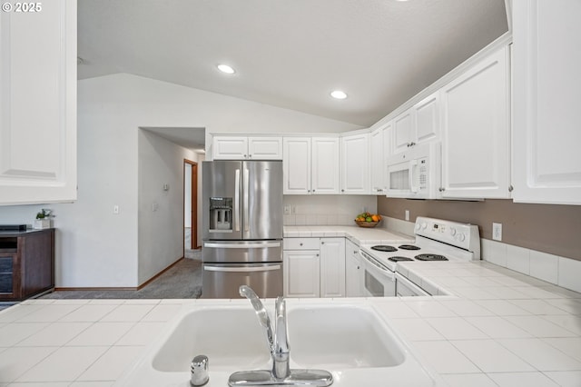 5661 J St, Washougal, WA 98671 - kitchen with white appliances, tile counters, lofted ceiling, a sink, and white cabinets