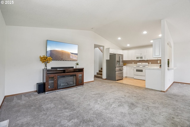 5661 J St, Washougal, WA 98671 - unfurnished living room featuring light colored carpet, lofted ceiling, baseboards, stairway, and recessed lighting