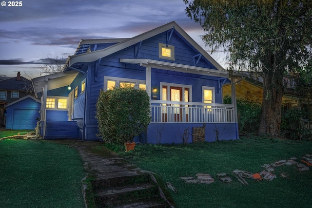 rear view of property with covered porch and a lawn