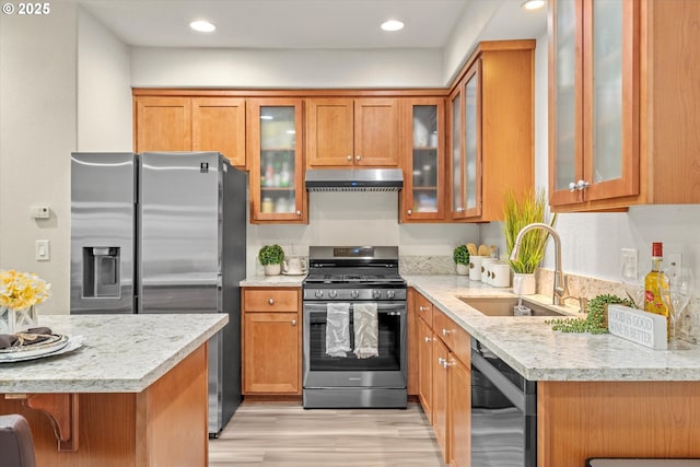 2590 NW 2nd Ter, Gresham, OR 97030 - kitchen featuring appliances with stainless steel finishes, under cabinet range hood, brown cabinets, light wood-style flooring, and recessed lighting