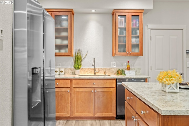 2590 NW 2nd Ter, Gresham, OR 97030 - kitchen with appliances with stainless steel finishes, light stone counters, brown cabinetry, and glass insert cabinets