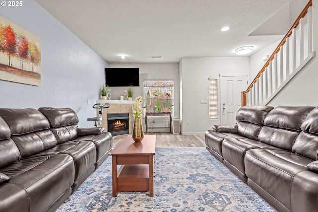 2590 NW 2nd Ter, Gresham, OR 97030 - living area with light wood-type flooring, stairs, a fireplace, a textured ceiling, and recessed lighting