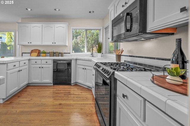 305 SW 169th Pl, Beaverton, OR 97006 - kitchen featuring black appliances, tile counters, plenty of natural light, white cabinets, and recessed lighting