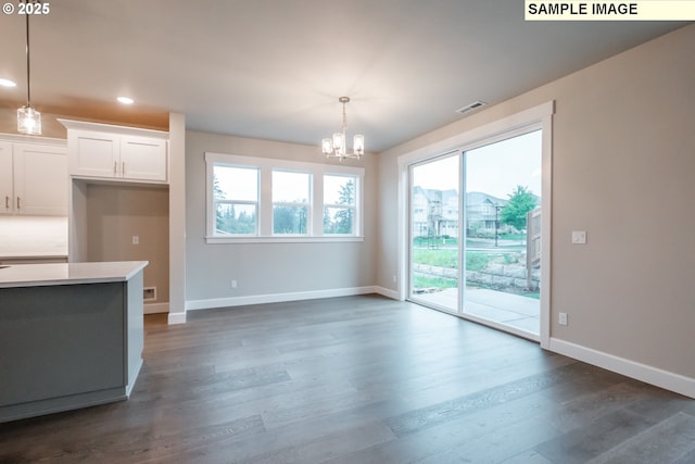 kitchen with a chandelier, baseboards, dark wood-type flooring, white cabinets, and hanging light fixtures