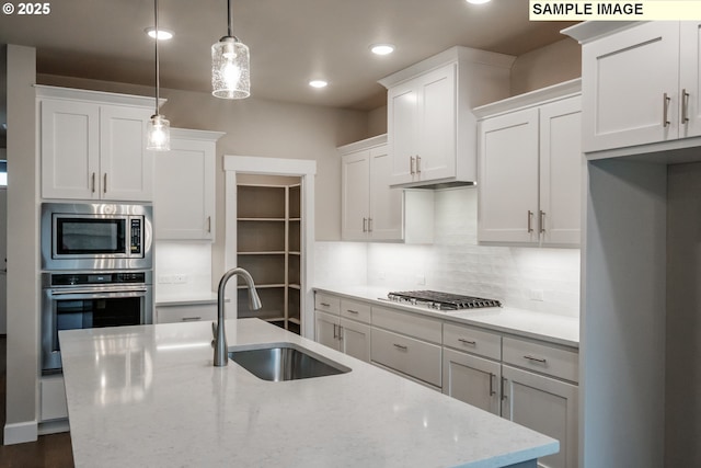 kitchen featuring a sink, stainless steel appliances, decorative backsplash, white cabinets, and recessed lighting