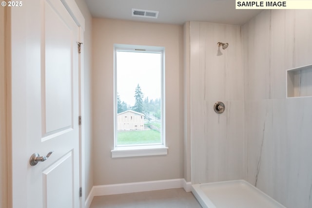 bathroom with a shower and baseboards