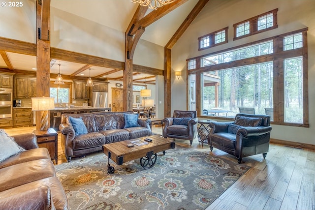 living room featuring a high ceiling, an inviting chandelier, beam ceiling, and light hardwood / wood-style flooring