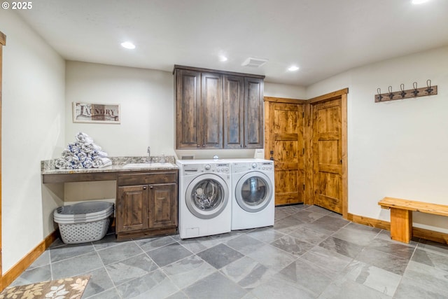 laundry room featuring cabinets, separate washer and dryer, and sink