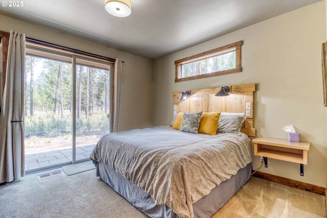 bedroom featuring access to exterior and light carpet