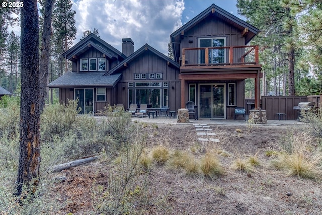 rear view of house with a patio area and a balcony