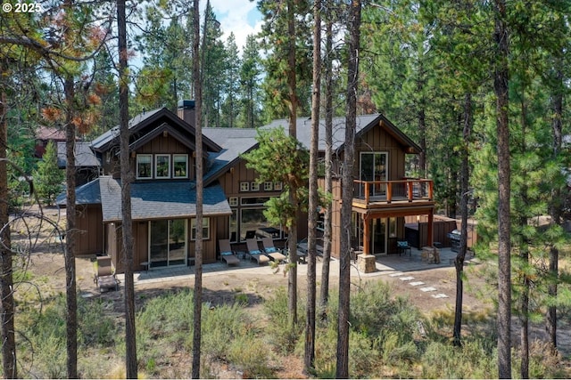 rear view of property featuring a patio and a wooden deck