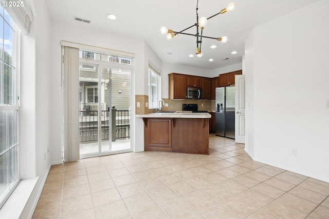 11660 SW Longspur Ter, Beaverton, OR 97007 - kitchen featuring stainless steel appliances, a chandelier, light countertops, plenty of natural light, and recessed lighting