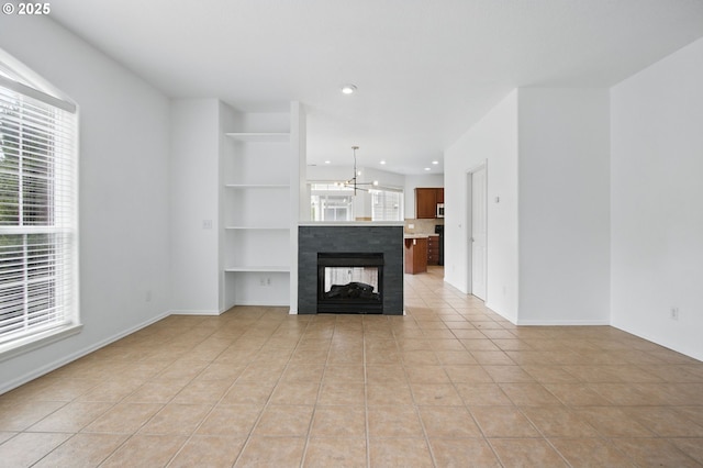 11660 SW Longspur Ter, Beaverton, OR 97007 - unfurnished living room with light tile patterned floors, recessed lighting, a chandelier, built in features, and baseboards