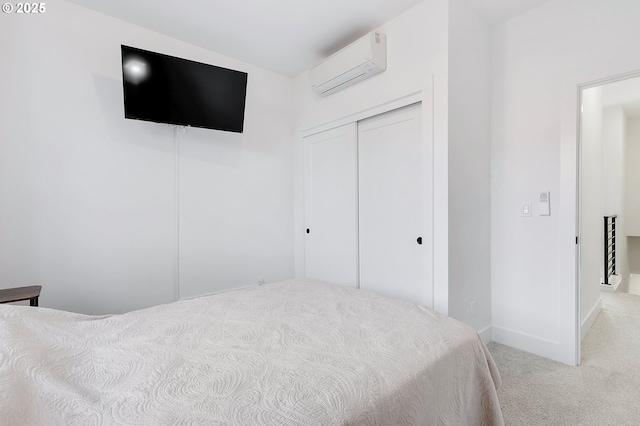 bedroom with carpet, a closet, and a wall mounted AC