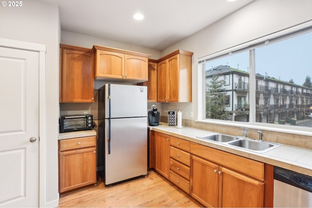 kitchen featuring sink, stainless steel appliances, and light hardwood / wood-style floors