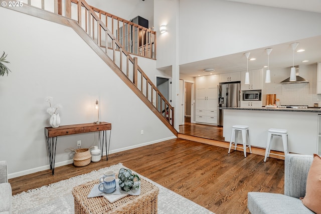1505 NW 118th Ct, Portland, OR 97229 - living room featuring stairway, a high ceiling, wood finished floors, and recessed lighting