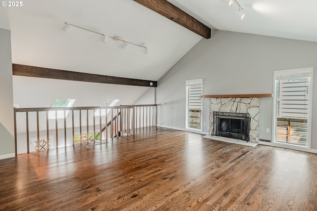 1505 NW 118th Ct, Portland, OR 97229 - unfurnished living room with track lighting, wood finished floors, a fireplace, and a skylight