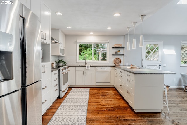 1505 NW 118th Ct, Portland, OR 97229 - kitchen with white appliances, a peninsula, healthy amount of natural light, dark countertops, and recessed lighting