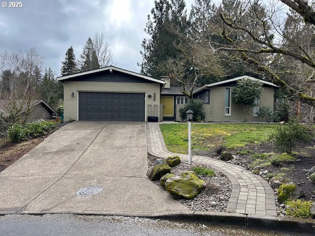 ranch-style house featuring a garage, a front yard, and driveway