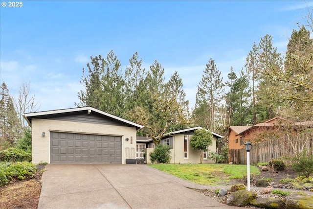 single story home with driveway, an attached garage, a front yard, and fence