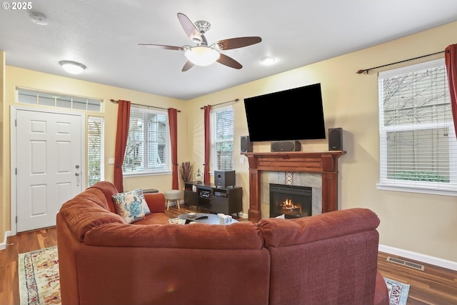 living room featuring a fireplace, wood-type flooring, and ceiling fan