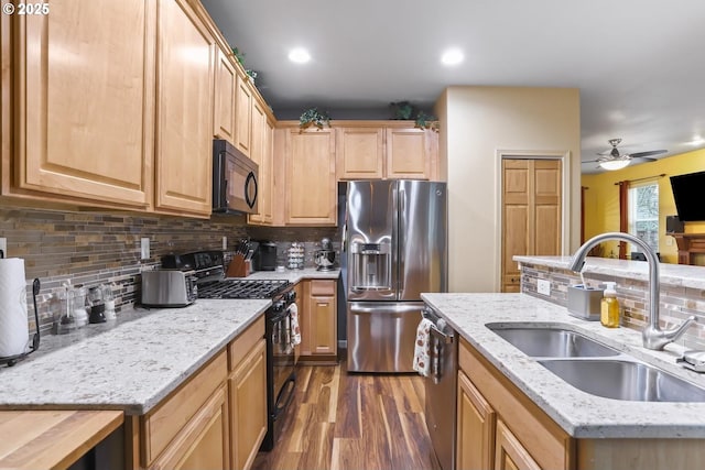 kitchen featuring black appliances, dark hardwood / wood-style flooring, decorative backsplash, sink, and ceiling fan