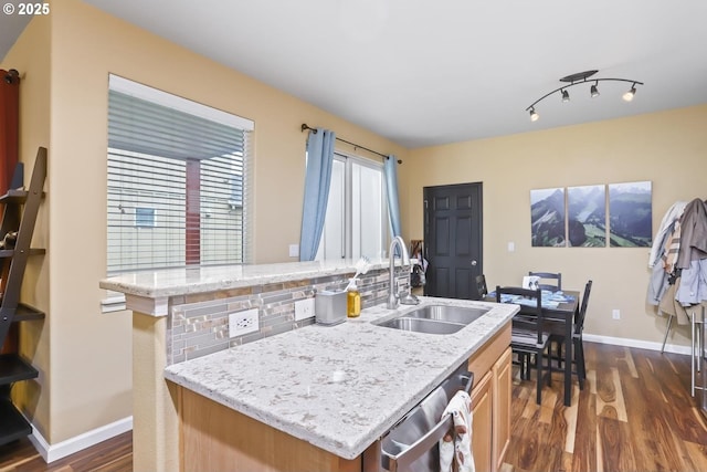 kitchen featuring sink, dishwasher, a kitchen island with sink, and dark hardwood / wood-style flooring