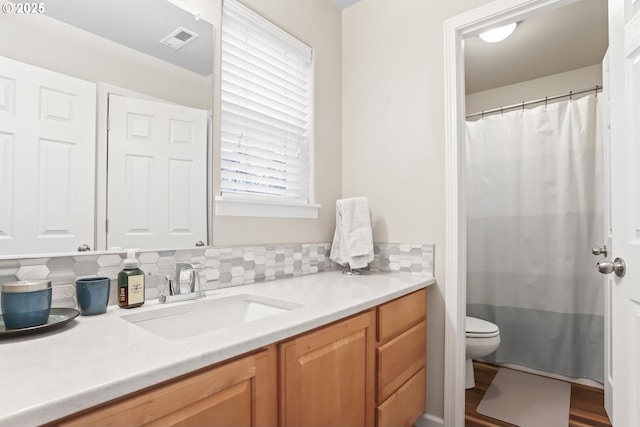 bathroom featuring plenty of natural light, toilet, a shower with shower curtain, and vanity