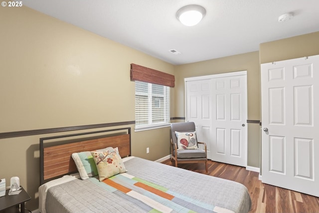 bedroom featuring dark hardwood / wood-style floors and a closet