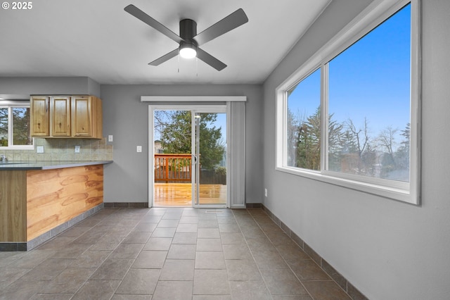 kitchen with tile patterned floors, backsplash, a ceiling fan, and baseboards