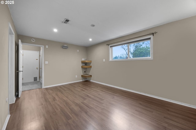 empty room featuring recessed lighting, visible vents, baseboards, and wood finished floors