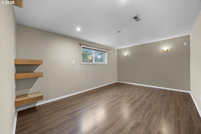 spare room featuring visible vents, baseboards, and wood finished floors