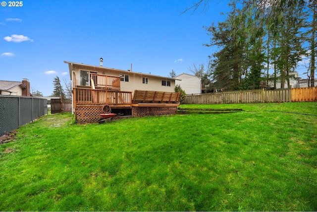 rear view of property with a fenced backyard, a wooden deck, and a yard