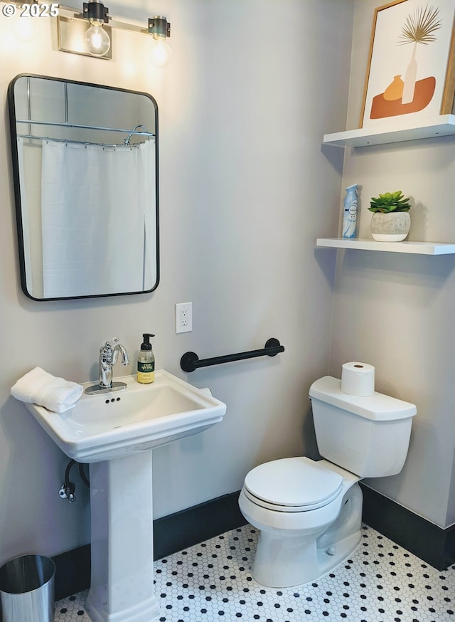 bathroom featuring tile patterned floors, curtained shower, and toilet