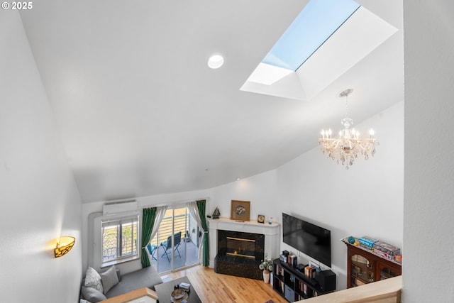 living area with a skylight, vaulted ceiling, a fireplace, a chandelier, and light wood-style floors
